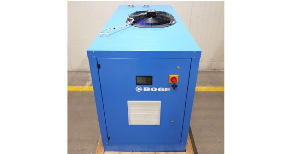 Blue BOGE air compressor unit with control panel and fan, placed on a wooden pallet in an industrial setting.