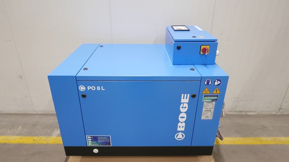 BOGE PO 8 L air compressor in blue, featuring a control panel and safety labels, placed indoors on a wooden pallet.