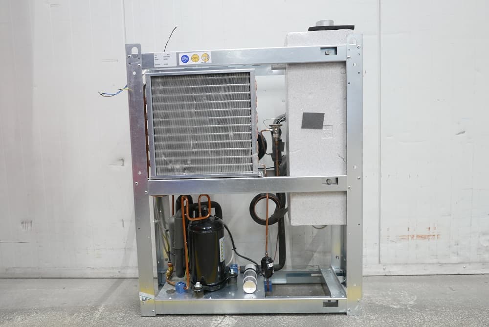 Industrial air drayer  unit with exposed components, including coils and piping, set against a plain background.