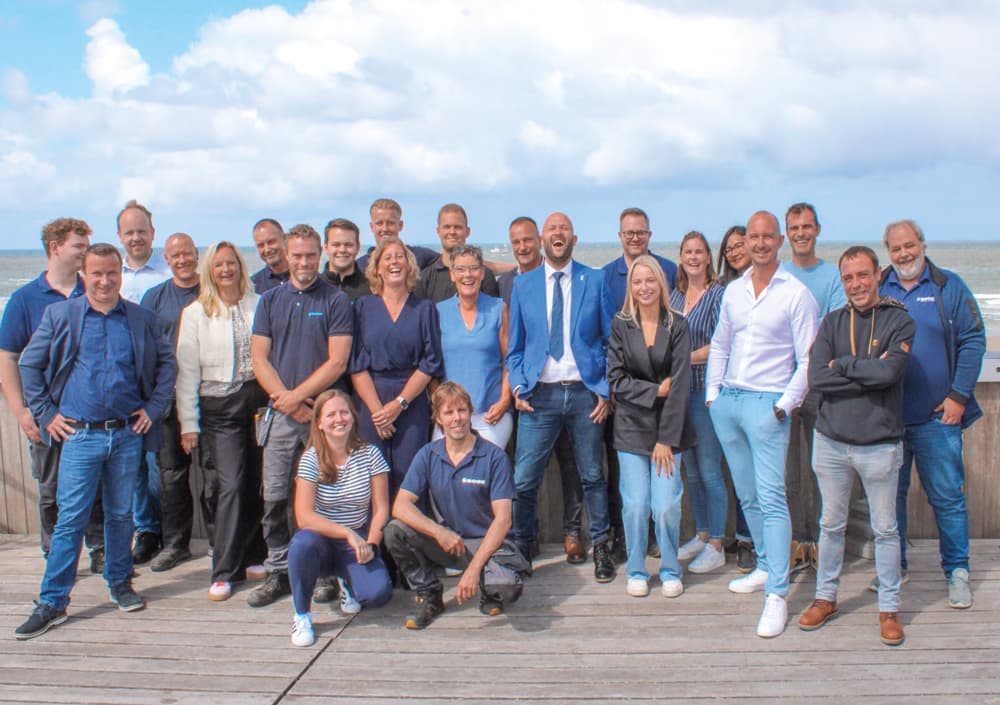 Gruppenbild der Mitarbeiter vom Team BOGE Belgien, die Gruppe steht draußen bei bewölktem Himmel
