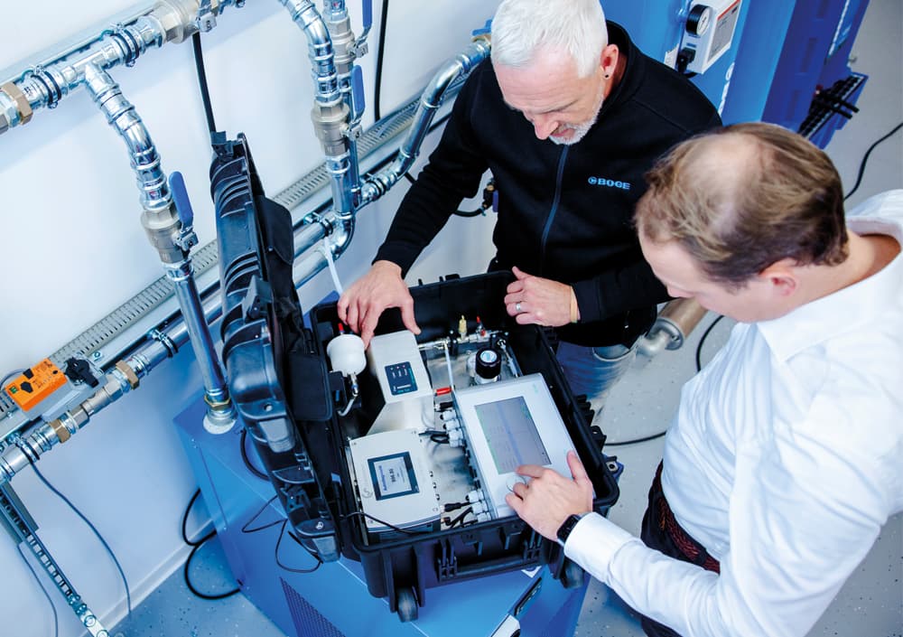 Zwei BOGE Servicetechniker, welche an einer Druckluftanlage eine Druckluftmessung durchfuehren.