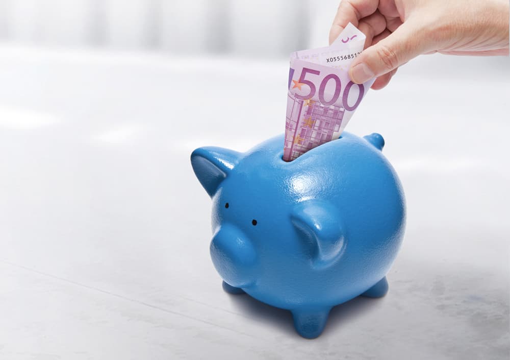 BOGE Sparschwein in Blau in das ein 500€ Schein gesteckt wird