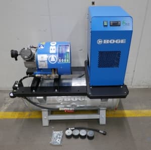 BOGE air compressor system with blue casing, mounted on a frame, includes accessories on the floor.