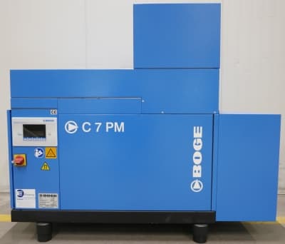 BOGE C 7 PM air compressor in blue, featuring a control panel and safety labels, designed for efficient compressed air solutions.