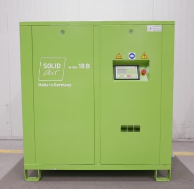 Green industrial air compressor labeled "SOLID Air screw 18 B," with control panel, made in Germany.