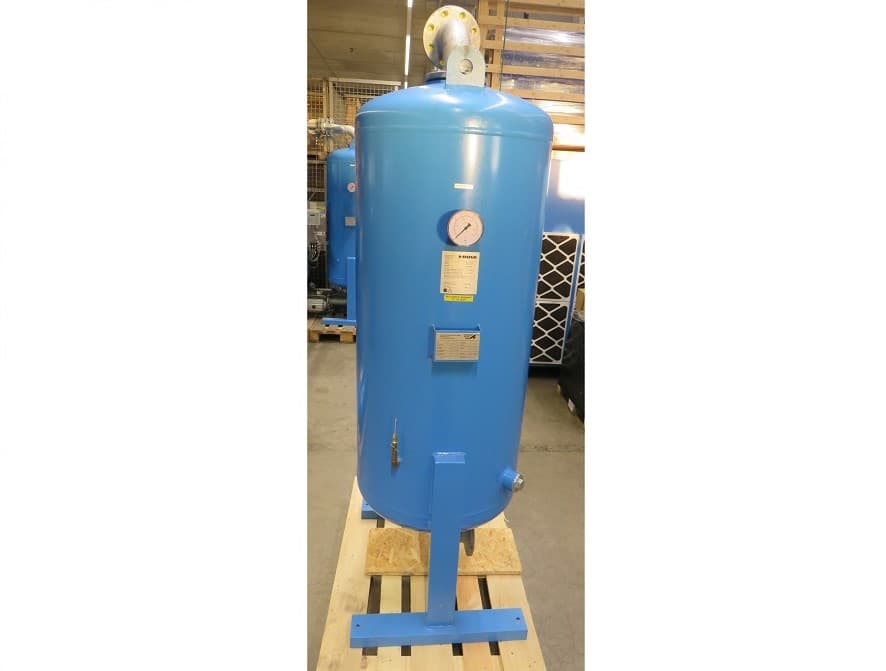 Blue Activated carbon adsorber with pressure gauge and labels, mounted on a wooden pallet in an industrial setting.