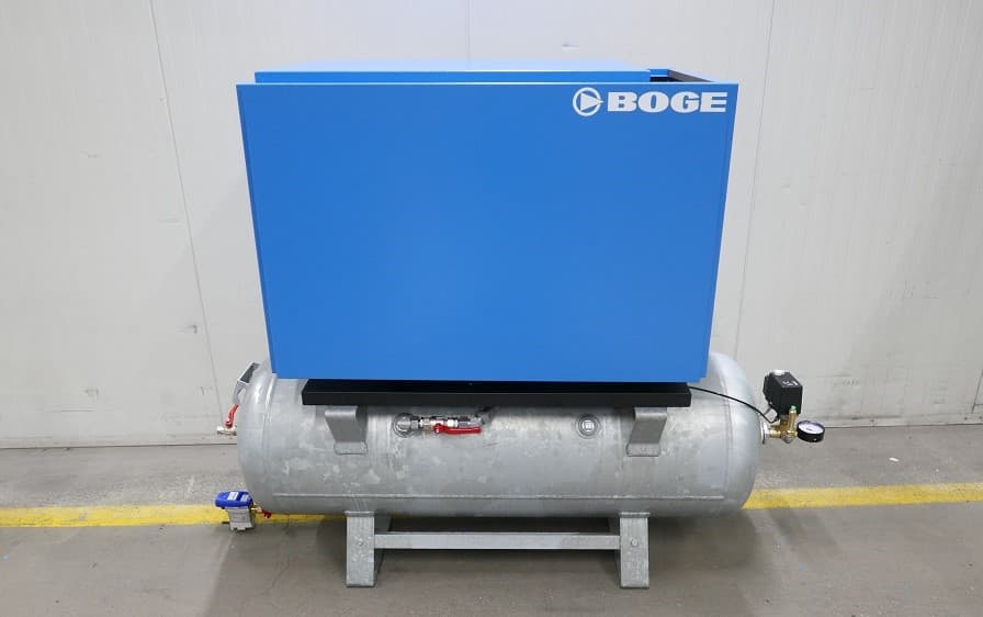 BOGE air compressor unit in blue, mounted on a silver receiver, positioned against a white industrial wall.