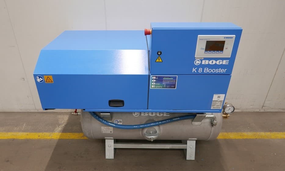 BOGE K 8 Booster air compressor with blue casing and control panel, mounted on a silver receiver, in an industrial setting.