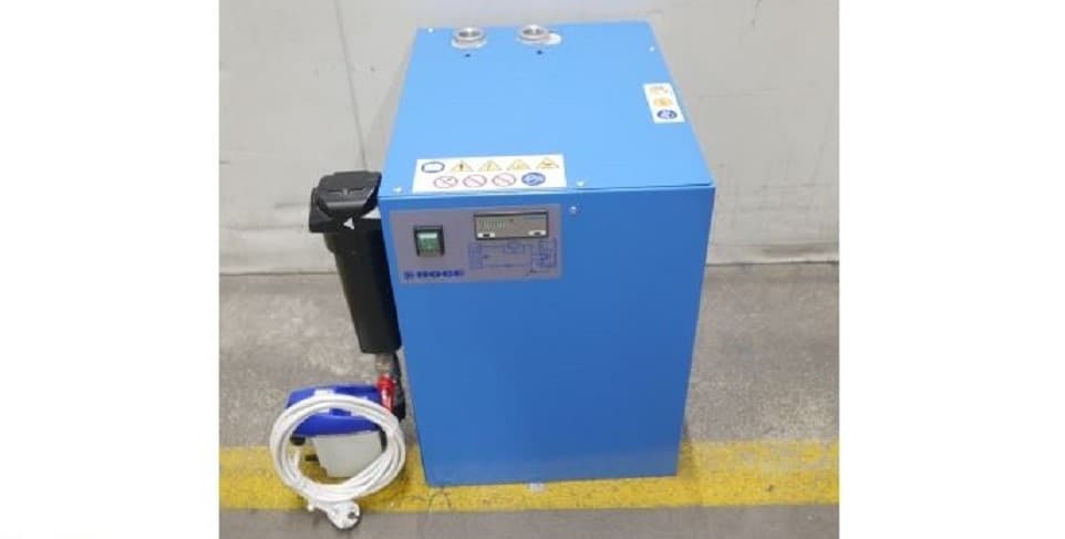 BOGE blue air compressor unit with control panel, placed on a concrete floor, accompanied by coiled hose and container.