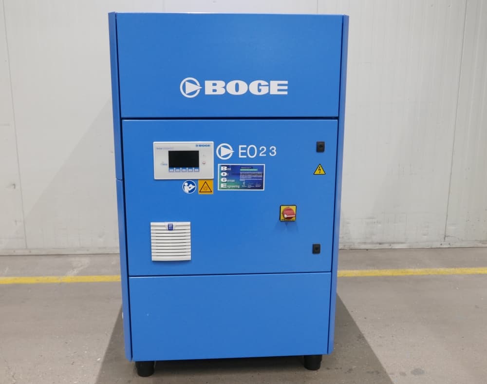 BOGE EO23 air compressor in blue, featuring a digital display and safety labels, set against a plain industrial background.
