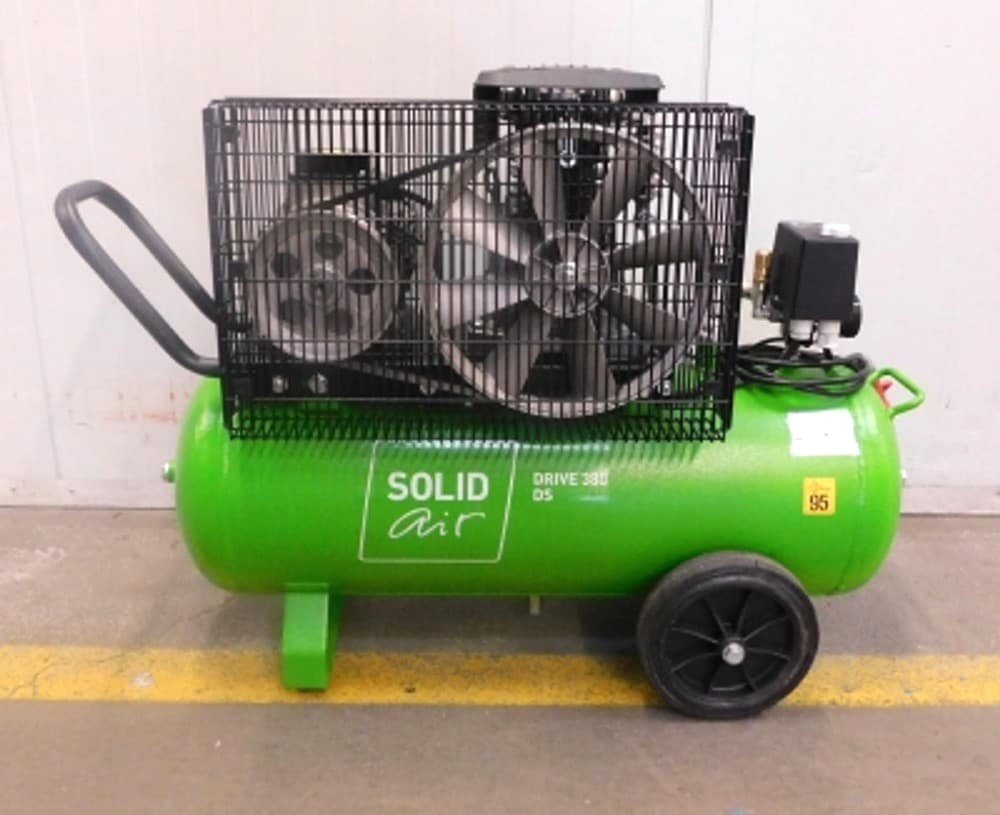Green portable air compressor with a protective cage, large wheels, and "SOLID air" branding on the side.