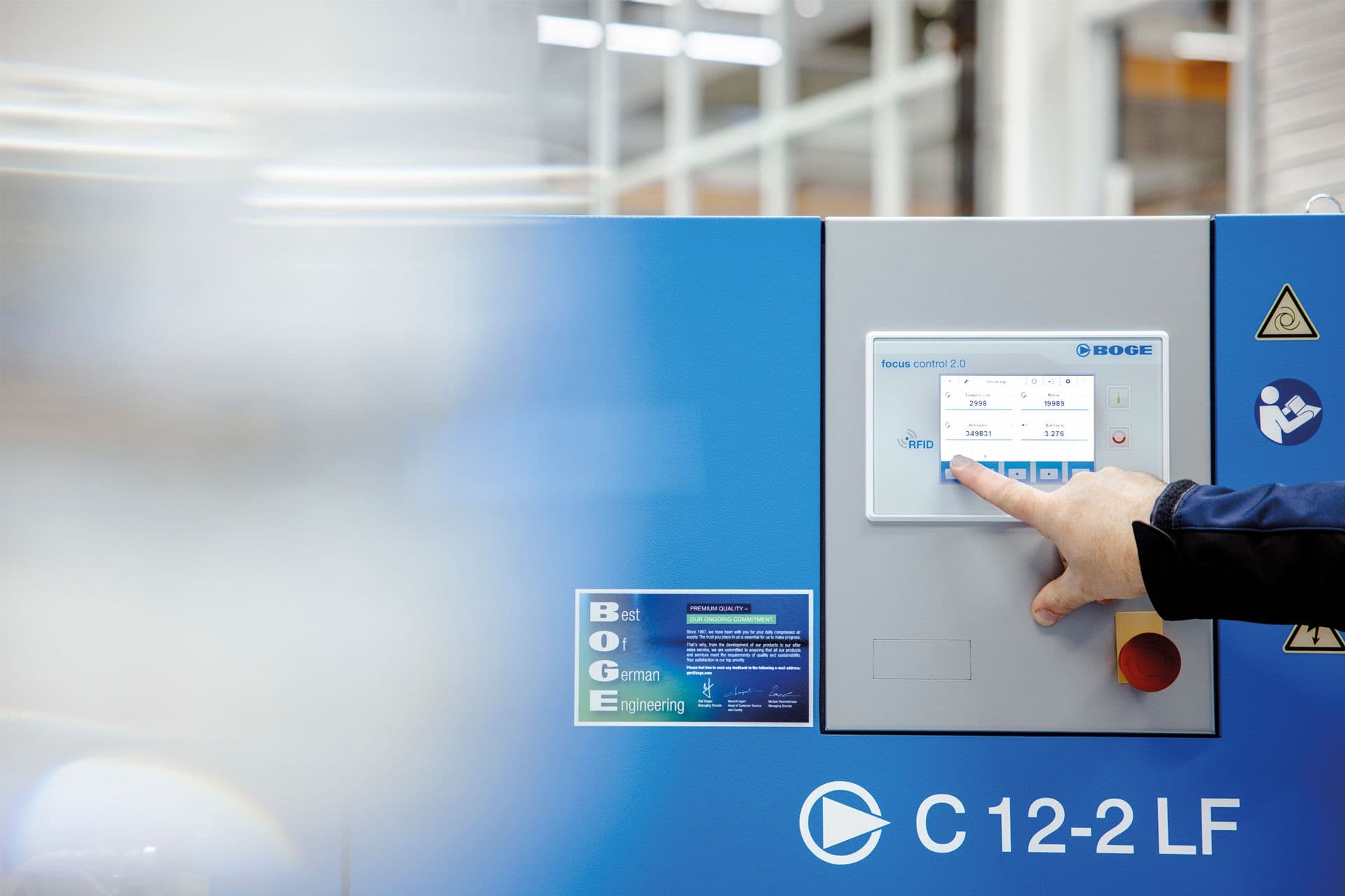 Person, die eine BOGE C 12-2 LF-Maschine mit Touchscreen-Schnittstelle in Innenräumen bedient.