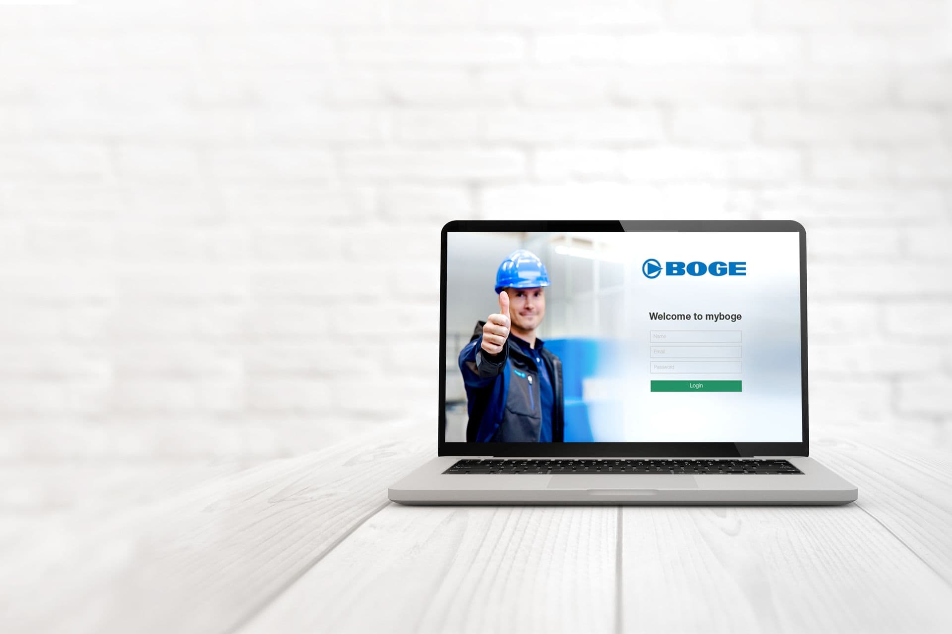 Das Bild zeigt einen Laptop auf einem Tisch, der Bildschirm zeigt einen Bogemitarbeiter und die Anmelde-Seite für das BOGE-Portal myboge