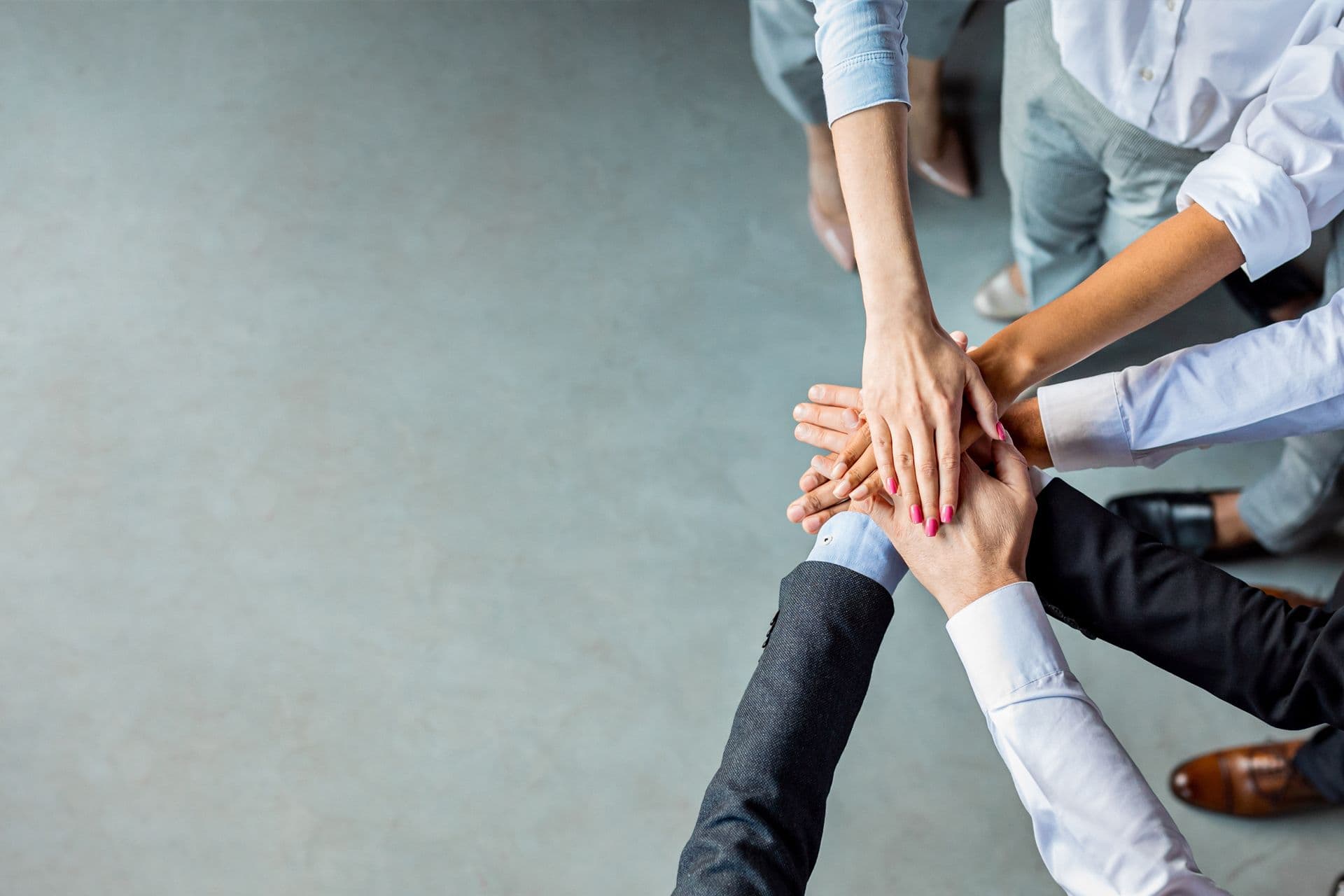 Mehrere Haende uebereinadner, die bei BOGE zusammenarbeit Symbolisieren soll