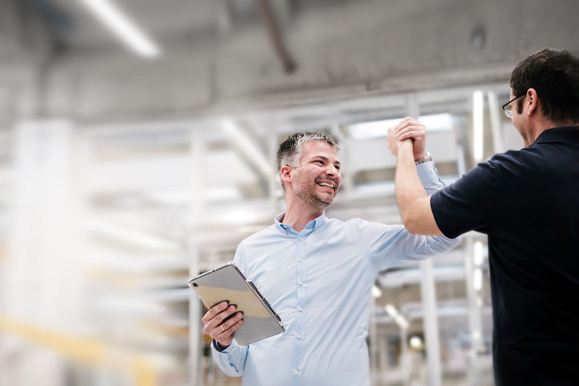 BOGE Mitarbeiter mit Tablet in der Hand und Kunde machen einen freudigen Handschlag