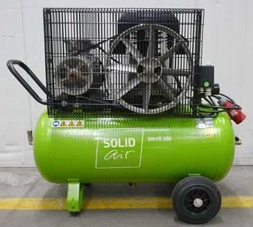 Green portable air compressor with protective cage, labeled "SOLID air DRIVE 500," featuring wheels and a handle for easy mobility.