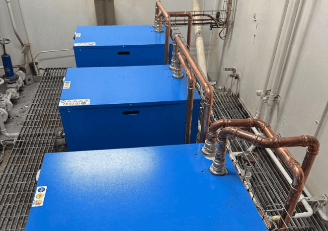 Three blue BOGE DT 80-2 refrigerant dryers connected by copper pipework onboard Queen Mary 2