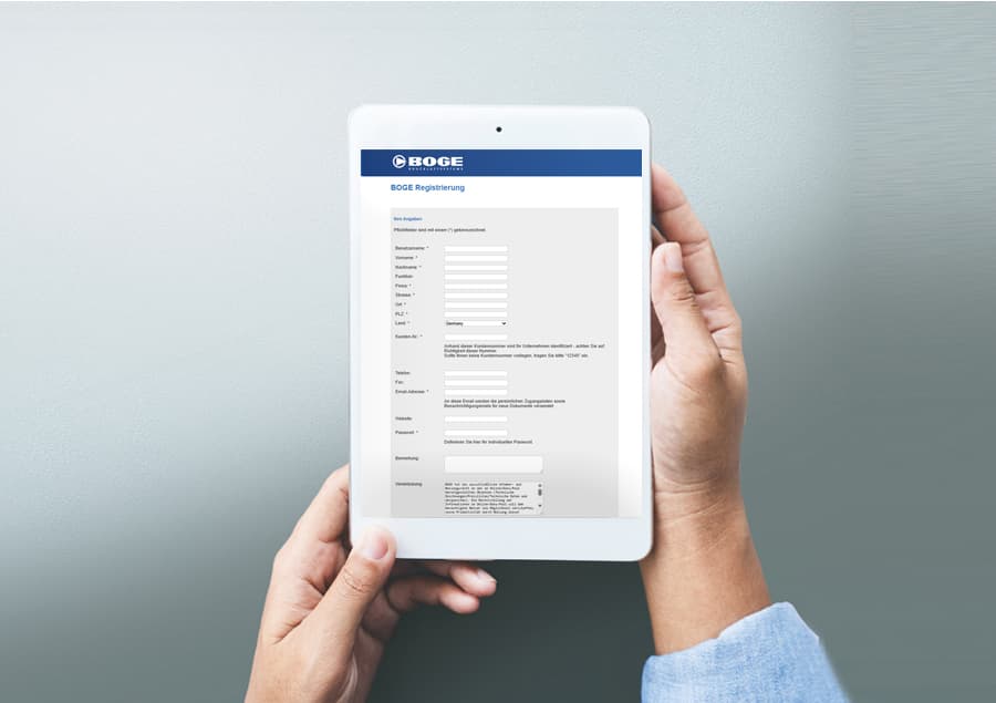 Person die ein Tablet in beiden Händen hält. Auf dem Tablet ist ein Formular zur Registration von dem Online-portal myboge abgebildet.